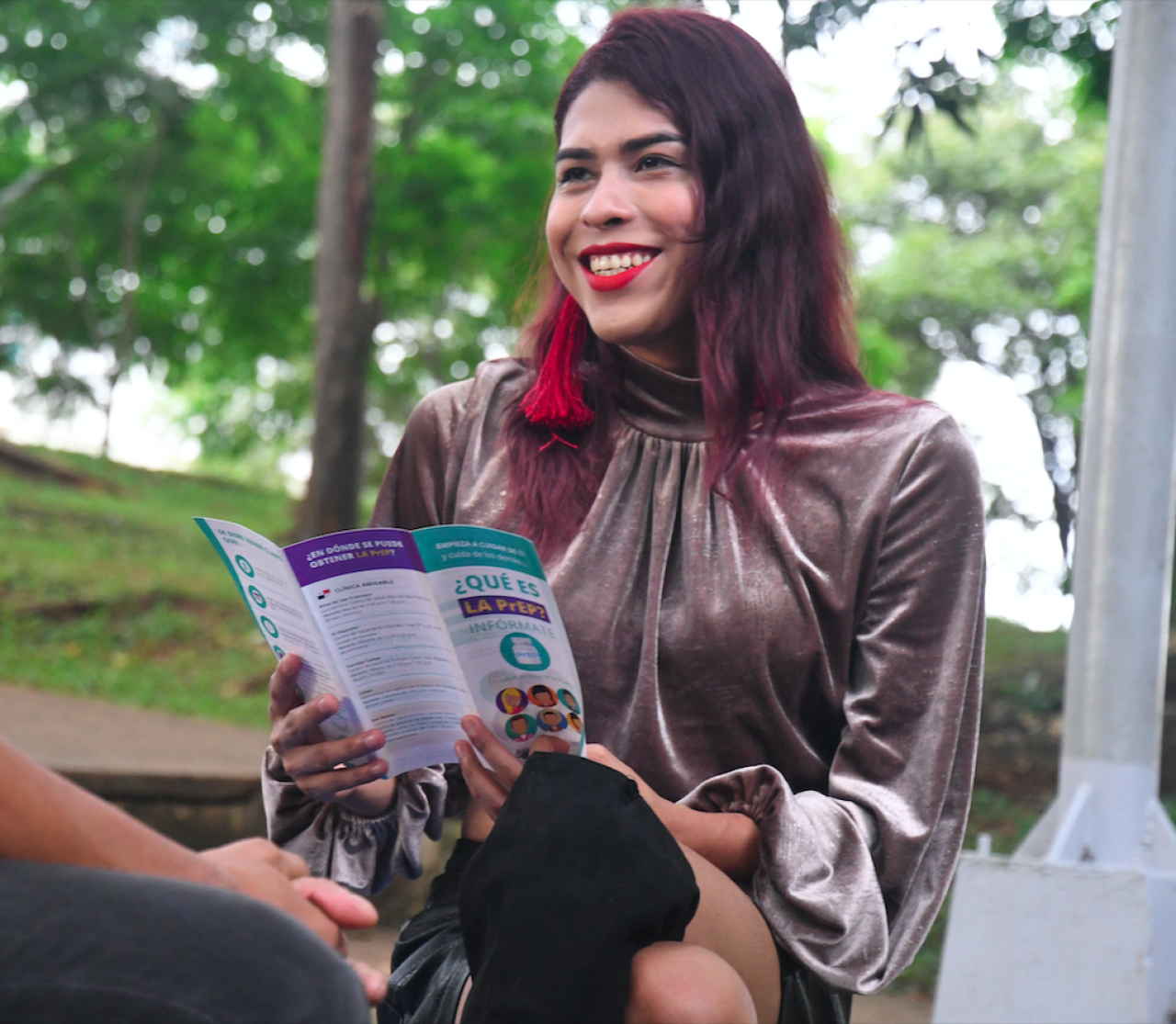 Woman smiles while holding a pamphlet