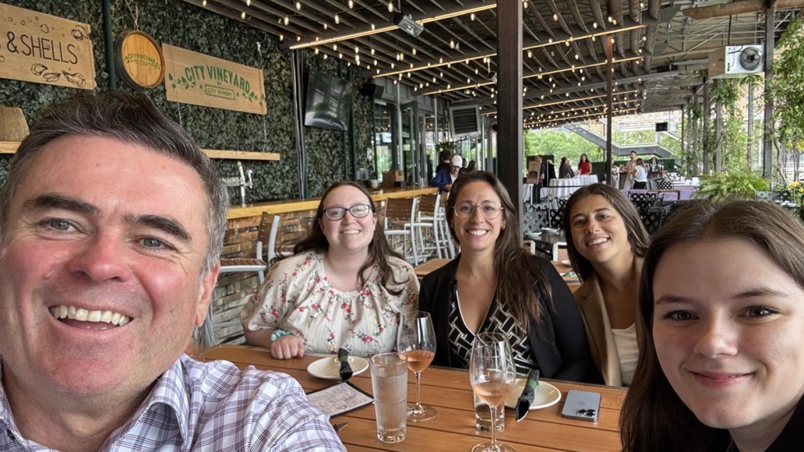 A group of coworkers sits in an outdoor restaurant