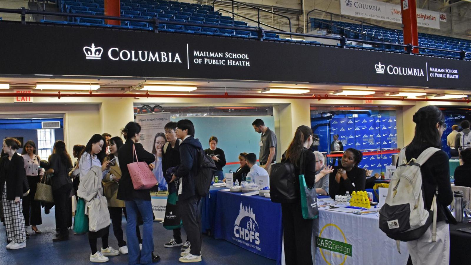 Students congregate near tables at career fair