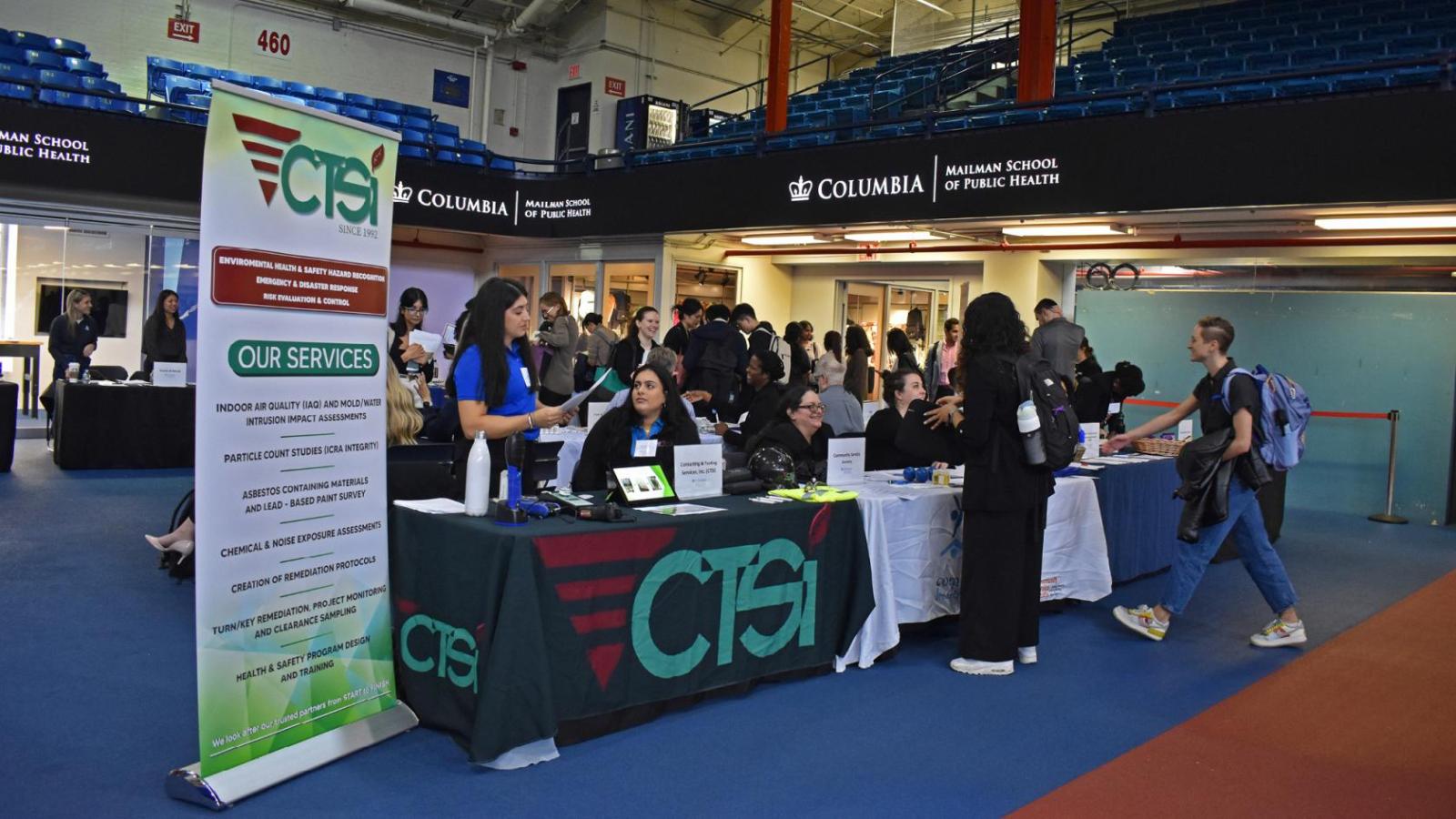 Students speak with employers at tables
