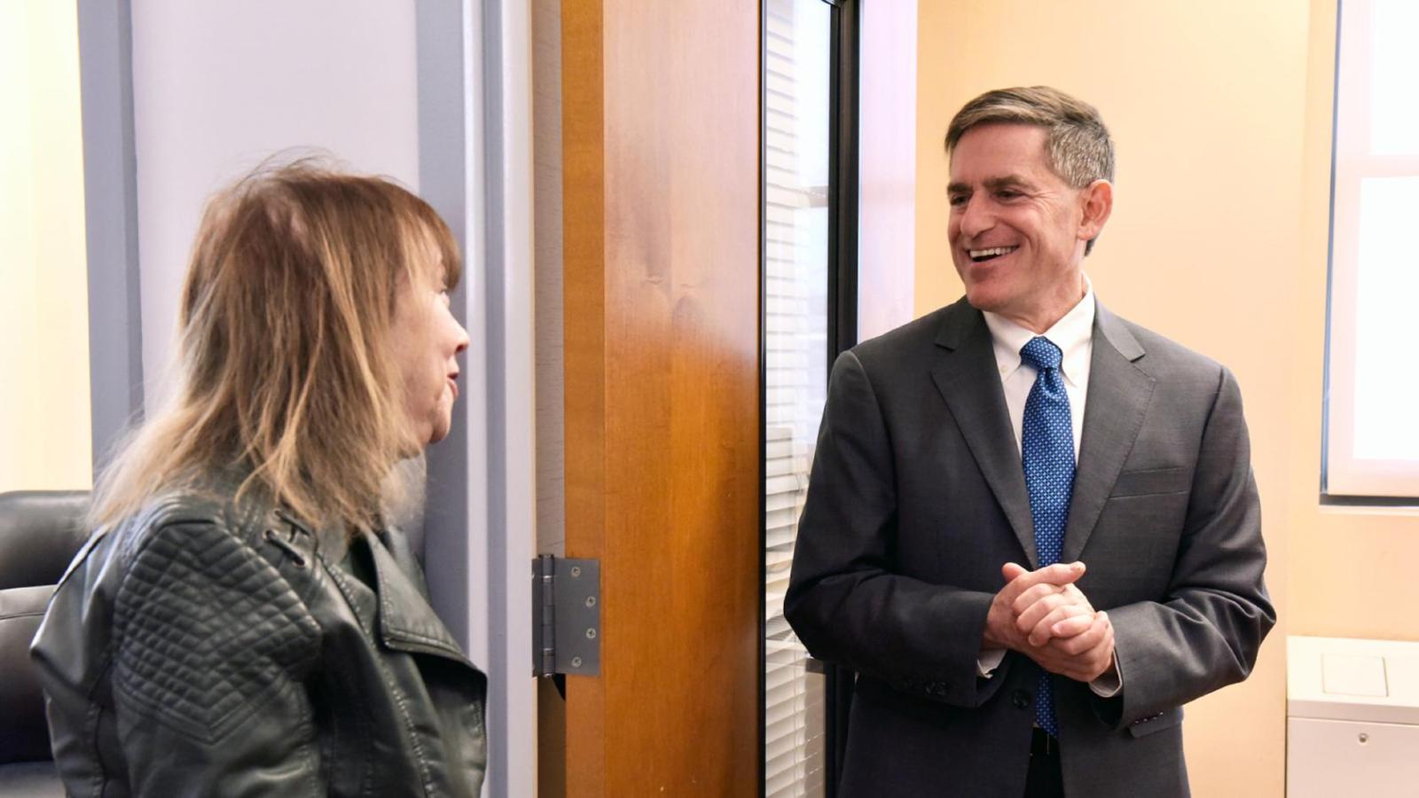 A standing woman and man facing each other