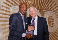 Kenneth Frazier and P. Roy Vagelos in front of a Centennial "100" logo
