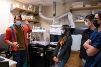 research scientist explains lab equipment to masters students