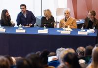 Two women and three men seated at a table.