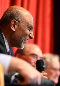 A smiling man holding a microphone