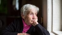 Elderly woman looking out window