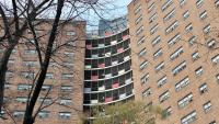 View of rounded red-brick apartment building from a low angle