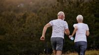 Photo of an older couple running together in warm weather