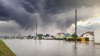 Photo of a flooded residential area with dark storm clouds