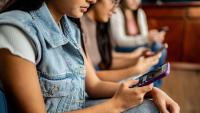 A group of young people holding cell phones