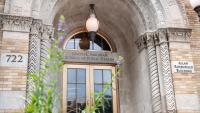 The entrance to the Allan Rosenfield Building with a flowering plant in the foreground
