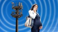 Pregnant woman on cell phone with radio frequency towers in background