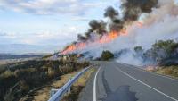 A wildfire on a hillside along a road in Spain