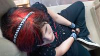 Female with colorful hair thinking in a reclining position
