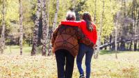 Older overweight woman walking with person in the park