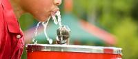 A photo of a boy drinking water from a water fountain