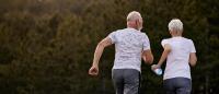 Photo of an older couple running together in warm weather