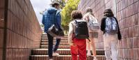 A photo of four young people walking up stairs