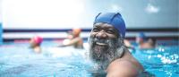 Smiling man with gray beard in pool