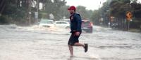 PALM BEACH, United States – November 09, 2022: The storm Nicole nears hurricane strength as a man jogs through flooded roads in the Palm Beach area.