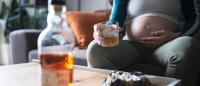 Pregnant female drinking and ashtray of cigarettes