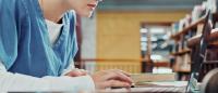 Student in scrubs on computer
