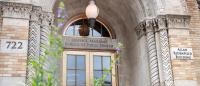 The entrance to the Allan Rosenfield Building with a flowering plant in the foreground