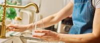 Pregnant female taking drinking water from tap