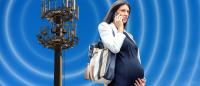 Pregnant woman on cell phone with radio frequency towers in background