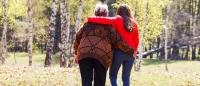 Older overweight woman walking with person in the park