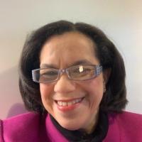 Headshot photo of a smiling woman wearing glasses