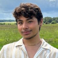 Man standing in front of a green field.