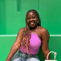 Maame Arthur sitting in front of a green wall
