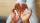 Black hands palms up hold a tampon and a menstrual cup